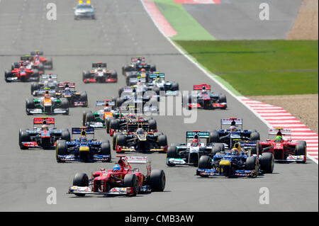 08.07.2012 Towcester, England. Fernando Alonso of Spain and Scuderia Ferrari leads from Mark Webber of Australia and Red Bull Racing through the first corner induring the Race at the Santander British Grand Prix, Round 9 of the 2012 FIA Formula 1 World Championship at Silverstone Circuit. Stock Photo