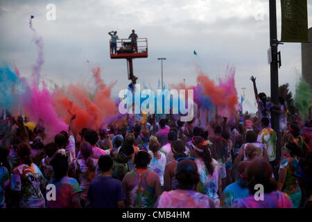 IOWA, USA. Sunday 8th July 2012. Color Me Rad race participants throw colored dye powder up into the air and are covered in a cloud of colorful powder dyes during the final group 'color bombing' at the Council Bluffs, Iowa race. Color Me Rad combines a 5K run/walk with being showered with colorful cornstarch and dye and benefits the Special Olympics. Stock Photo