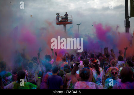 IOWA, USA. Sunday 8th July 2012. Color Me Rad race participants throw colored dye powder up into the air and are covered in a cloud of colorful powder dyes during the final group 'color bombing' at the Council Bluffs, Iowa race. Color Me Rad combines a 5K run/walk with being showered with colorful cornstarch and dye and benefits the Special Olympics. Stock Photo