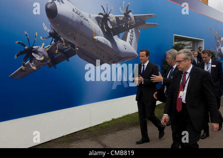 Farnborough, UK 09/07/12 British Prime Minister David Cameron walks past one of the Airbus exhibition stands at the Farnborough Air Show, England. Helping to launch this expo held for the international aviation and aerospace industries, Cameron toured stands to help promote trade and investment for this 48th airshow (FIA)and hailed the phenomenal success of the UK aerospace industry and its critical importance to growth and jobs. Farnborough is attended by an international business audience including 83 trade and military delegations from over 43 countries. Stock Photo