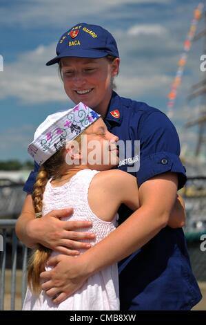 New London, Connecticut, USA - July 9, 2012: Nine-year-old Amelia Baca greets her sister, United States Coast Guard 3rd Class Cadet Micaela Baca, at the pier at Fort Trumbull where the Coast Guard Barque Eagle, on which Cadet Baca has been training, is moored for the balance of OpSail 2012 CT which ends today with the various ships sailing back to their home ports. The Eagle’s home port is New London, Connecticut. Amelia, a triplet, came with her mother and two triplet brothers from their home in Lexington, Virginia to visit their sister the cadet. See also photograph CMB8XX Stock Photo