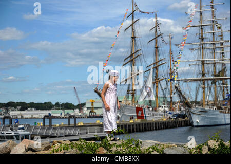 The young sister of a US Coast Guard cadet climbs along the shore in front of America's tall ship the historic three-masted barque Eagle in its home port of Fort Trumbull in New London Connecticut where it is usually docked and can be visited in summer and the Brazilian tall ship, the Cisne Branco (White Swan). Her sister is a cadet training on the Eagle (I also have a photo of them together - . See CMB8XW). Please see original Live News Caption in Optional Info. Stock Photo