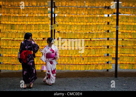 July 14, 2012 - Tokyo, Japan - Two Japanese girls dressed in yukata express themselves in an area of lanterns during the annual Mitama festival at Yasukuni Shrine. There are over 30,000 lanterns beautifully lit to comfort the souls of the dead during the four-day long festival where more than 2.4 million war dead are enshrined. (Photo by Christopher Jue/AFLO) Stock Photo