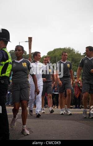 Bournemouth, UK Friday 13 July 2012. Olympic Torch Relay at Bournemouth, UK - runner Ian Kennedy, Wimborne Athletics Club coach, takes the torch into the Lower Gardens at Bournemouth on Friday evening Stock Photo