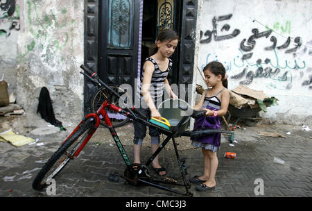 July 14, 2012 - Rafah, Gaza Strip, Palestinian Territory - Palestinian children clean the motorcycle at water as hot weather hits the southern Gaza Strip  (Credit Image: © Eyad Al Baba/APA Images/ZUMAPRESS.com) Stock Photo