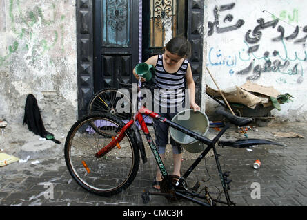 July 14, 2012 - Rafah, Gaza Strip, Palestinian Territory - A Palestinian child cleans the motorcycle at water as hot weather hits the southern Gaza Strip  (Credit Image: © Eyad Al Baba/APA Images/ZUMAPRESS.com) Stock Photo