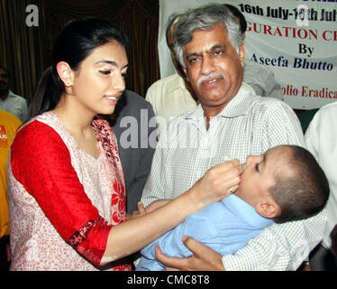 Asifa Bhutto Zardari, daughter of President Asif Ali Zardari,  administers Polio drops to a child during the inauguration ceremony of National Immunization  Days held at Bilawal House in Karachi on Monday, July 16, 2012. Stock Photo