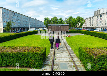 Drancy, France, Shoah Memorial in Suburbs, Camp Drancy, Holding Place, Where in WWII, Nazi Deportations of Jews and other Foreigners, 1941, to German Death Camps, took place, Couple Visiting Memorial Box Car Train, persecution of jews in europe, housing projects, holocaust jews paris wwii Stock Photo