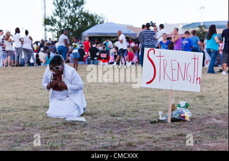 Aurora, Colorado, USA. 20th July, 2012. A crowd gathers for an impromptu prayer vigil across the street from the Century 16 Theater on July 20, 2012. Marietta Perkins from Mary Sanctuary prays for the shooting victims. Stock Photo