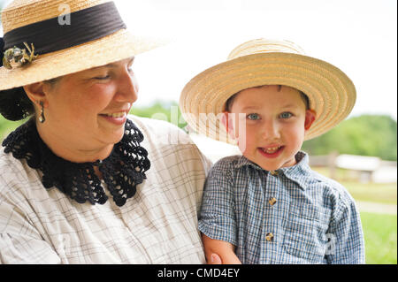 Old Bethpage, New York, USA - July 21, 2012: MICHELE WALKER of Coram and her son ROBERT WALKER, 4, wear clothes of American Civil War era while portraying family members of Union soldiers at Camp Scott re-creation, at Old Bethpage Village Restoration, to commemorate 150th Anniversary of American Civil War, on Saturday, July 21, 2012. Stock Photo