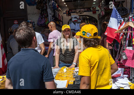 Paris,France,July 22 2012: Image of a young pretty woman selling souvenirs at a stand in a crowded street in Paris downtown, during the day of the last stage of Le Tour de France 2012. Stock Photo