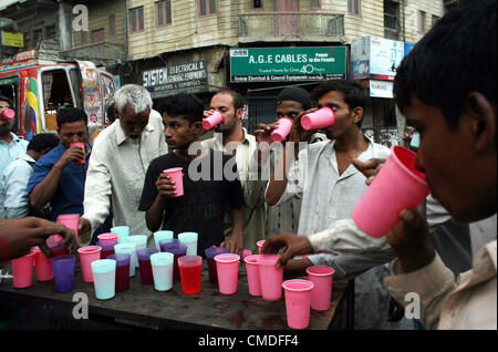 Faithful Muslims break their fast during Iftari (breaking fast  meal) the Holy month of Ramadan-ul-Mubarak at Burns road in Karachi on Tuesday, July 24,  2012. Stock Photo