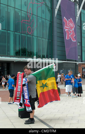 Manchester, UK. 26th July, 2012. A flag and scarf seller outside Old Trafford, Manchester United's ground, where the first Olympic Football matches at the ground were to be played later in the afternoon. Uruguay v United Arab Emirates was to be followed by Great Britain v Senegal, 26-07-2012 Stock Photo