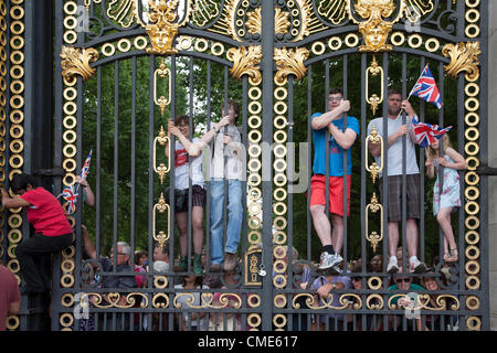 Olympics spectators climb Green Park's Royal Gates to watch the Men's Cycling Road Race pass by Buckingham Palace, London, on 28 July 2012. Crowds thronged the route to watch the race, which was won by Alexander Vinokourov of Kazakhstan Stock Photo