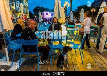 Paris, France - Medium Crowd People Viewing Olympics Live Broadcast on Public Screen at City Hall, 'Paris Plages', Sharing Drinks, at Terrace Bar at Night, holiday sports audience Stock Photo