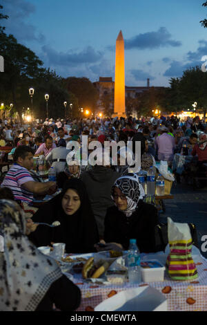 Istanbul, Turkey. Tuesday 31st July 2012. Ramazan (Ramadan) is almost half over. Muslims picnicking on tables provided by the municipality of Sultan Ahmet district, the old city of Istanbul, Turkey. This is the square in front of the Blue Mosque, with the obelisk in the background Stock Photo