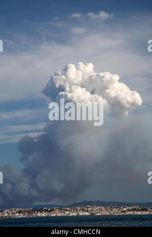 10th Aug 2012. Smoke plume rising over the karst hills and drifting over Trieste city and bay. The smoke is from a huge pine forest fire near Črni Kal in Western Slovenia. The fire is believed to have possibly been started by the sparks from a passing train. Stock Photo