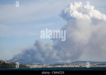 10th Aug 2012. Smoke plume rising over the karst hills and drifting over Trieste city and bay. The smoke is from a huge pine forest fire near Črni Kal in Western Slovenia. The fire is believed to have possibly been started by the sparks from a passing train. Stock Photo