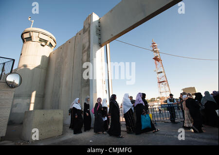 BETHLEHEM, WEST BANK - AUGUST 17, 2012: Palestinian women pass through the Israeli military Bethlehem checkpoint controlling access to Jerusalem through the separation wall on the last Friday of Ramadan. Stock Photo