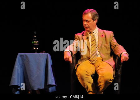 Ukip leader, Nigel Farage MEP looks to glass of red wine on stage at Buxton Opera House during his UK theatre tour 2013. Stock Photo