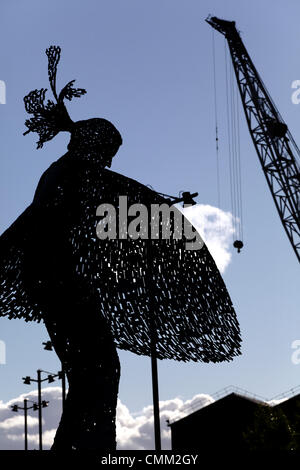 Glasgow Harbour, Partick, Glasgow, Scotland, UK, Monday, 4th November, 2013. Following an announcement that the iconic cranes in the BAE System Shipyard at Govan on the River Clyde are scheduled to be dismantled concerns have been raised that the yard may be destined to close. Silhouette of the modern steel sculpture Rise by Andy Scott and the the jib of a BAE Systems shipyard crane. Stock Photo