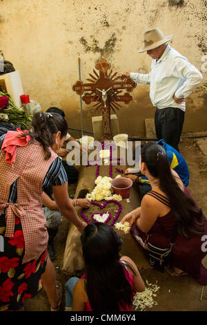 A Mexican family decorates the gravesite of a loved one at the richly decorated San Antonillo Castillo Velasco Cemetery during the Day of the Dead Festival known in Spanish as D’a de Muertos on November 3, 2013 in Ocotlan, Oaxaca, Mexico. The cemetery has a competition for the best decorated grave. Stock Photo