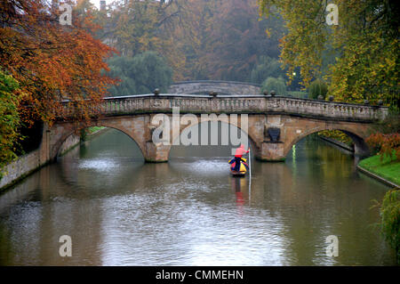 Cambridge, UK. 6th November 2013. Tourists brave the cold temperatures and heavy rain punting in Cambridge UK 6th November 2013. Whatever the weather the punt trade continues on the River Cam providing views of the famous 'Backs' of some of the University buildings. Credit Julian eales/Alamy Live News