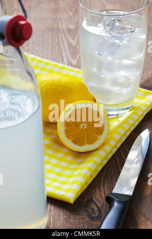 Still life photo of old fashioned or traditional homemade still lemonade with cut lemons and yellow napkin.. Stock Photo