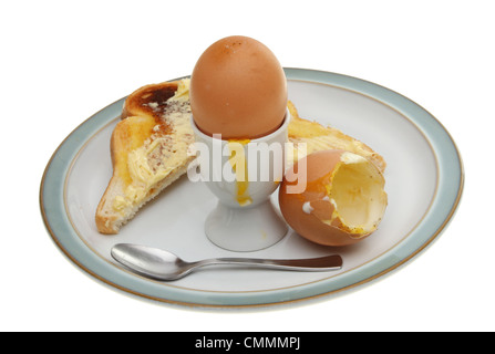 Soft boiled eggs with toast and a spoon on a plate isolated against white Stock Photo
