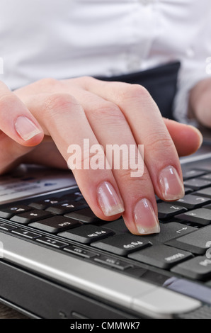 woman pressing enter key on the laptop computer keyboard, selective focus on key-press Stock Photo