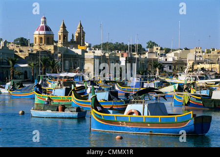 View across harbour with traditional Luzzu fishing boats, Marsaxlokk, Malta, Mediterranean, Europe Stock Photo