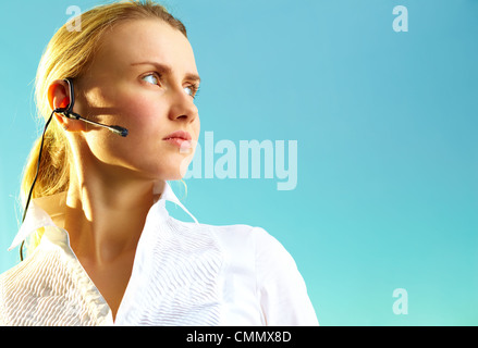 Image of pretty woman with headset on blue background Stock Photo