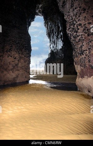 a view from the inside of a beach cave looking out at the sea Stock Photo