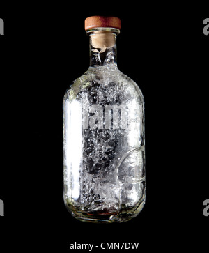 Glass bottle with cork top and bubbling liquid inside Stock Photo