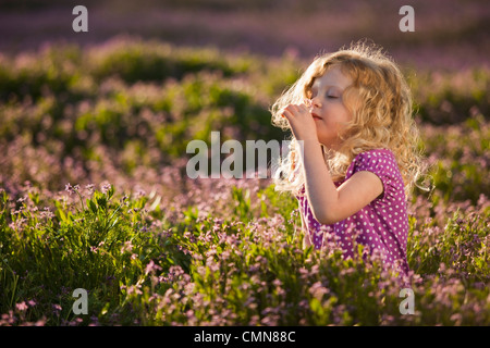 Portrait of girl smelling flowers, side view Stock Photo - Alamy