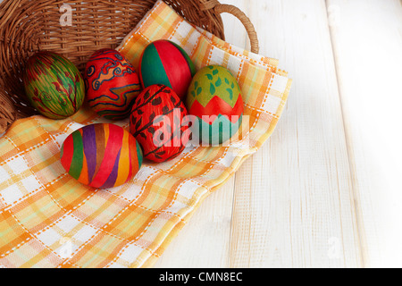 colorful Easter eggs on plaid napkins and rattan baskets Stock Photo