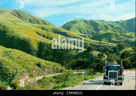 Semi-truck driving on remote highway Stock Photo