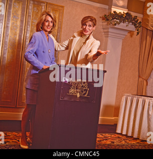 Two women business executives prepare speech at conference podium. Stock Photo