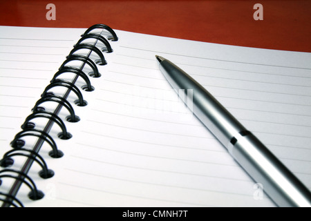 A silver pen on a blank page of notebook. Stock Photo