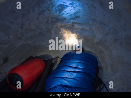A man sleeping inside a snow cave. Stock Photo