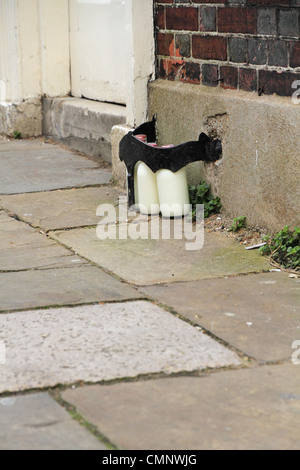 Glass bottles of delivered fresh milk on the street outside the front door of a house in Lewes, East Sussex, England. Stock Photo