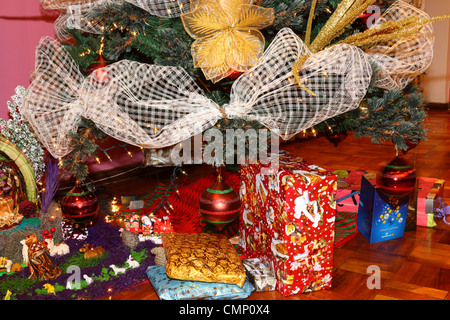 Detail of Christmas tree with decorations, presents, cards and part of a nativity scene Stock Photo