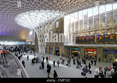 Kings Cross Railway Station departure concourse structural steel supports for roof structure beside old station brick walls Stock Photo