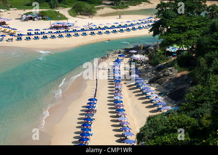 Parasols on a sandy beach with crystal clear turquoise water along Naiharn Beach, Phuket Island, Thailand Stock Photo