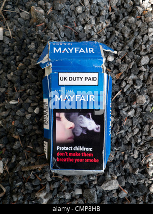 A discarded cigarette packet cigarettes depicting a child breathing smoke and a passive smoking danger to health warning notice UK  KATHY DEWITT Stock Photo