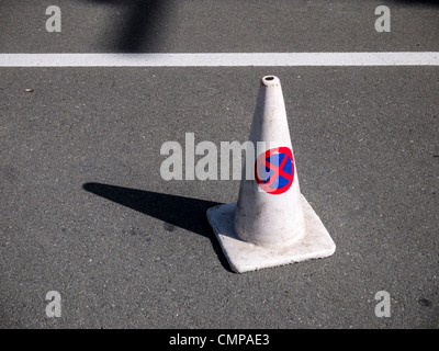 A white traffic cone with the red and blue 'no parking / no stopping' sign printed on it. Stock Photo