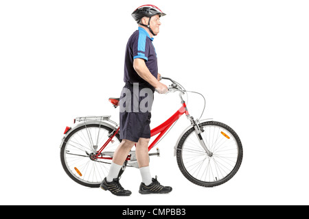 Full length portrait of a senior bicyclist pushing a bicycle isolated on white background Stock Photo