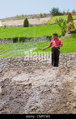 Lima Peru,Barranco,Bajada de los Banos,neighborhood,hillside,terraced garden,lawn,Hispanic man men male adult adults,hose,water,spraying,dirt,soil,roc Stock Photo