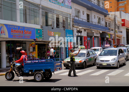 Tacna Peru,Calle San Martin,commercial district,storefront,street scene,traffic,stopped,tricycle,cart,car,Hispanic man men male adult adults,traffic,c Stock Photo
