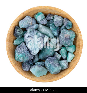 raw emerald gemstones (mineral beryl) with inclusions mined in Brazil, small wooden bowl isolated on white Stock Photo